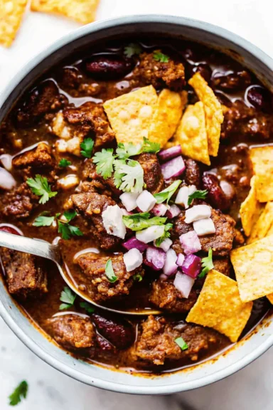 Steak chili served with fresh onions and cilantro.